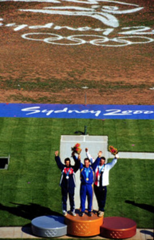 Sgt. 1st Class James T. Graves (right) joins his competitors on the medals platform after winning the bronze medal in the Men's Skeet competition at the 2000 Olympic Games in Sydney, Australia, on Sept. 23, 2000. Graves is one of fifteen U.S. military athletes competing in the 2000 Olympic games as members of the U.S. Olympic team. In addition to the 15 competing athletes there are eight alternates and five coaches representing each of the four services in various venues. Graves is attached to the U.S. Army Marksmanship Unit, Fort Benning, Ga. Graves is on the podium with silver medalist Petr Malek (left), of the Czech Republic, and gold winner Mykola Milchev (center) of Ukraine. 
