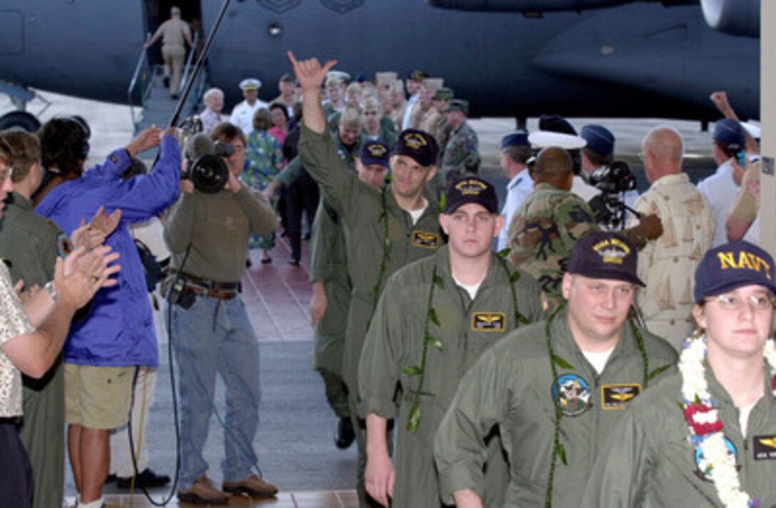 Navy Petty Officer Josef Edmunds waves to the crowd welcoming him and his fellow crew members of the detained EP-3 to Hickam Air Force Base, Hawaii, on April 12, 2001. The crew will stay in Hawaii for military debriefings before a final reunion with families and friends on the mainland. The crew was detained for 11 days after their EP-3 Aries II reconnaissance aircraft made forced landing on Hainan Island as a result of a collision with a Chinese F-8 fighter aircraft. Edmunds, a Navy Cryptological Technician, is from Davis, Calif. 