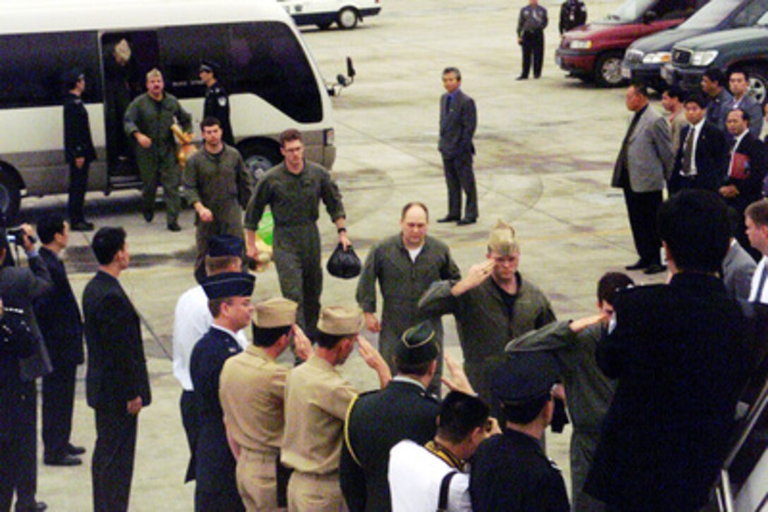 Members of the detained EP-3 crew salute as they board a chartered aircraft which will fly them from Haikou, China, to Guam, on April 12, 2001, during Operation Valiant Return. The crew will stop briefly in Guam to change planes and will then continue on to Hawaii for military debriefings before a final reunion with families and friends on the mainland. The crew was detained for 11 days after their EP-3 Aries II reconnaissance aircraft made forced landing on Hainan Island as a result of a collision with a Chinese F-8 fighter aircraft. 