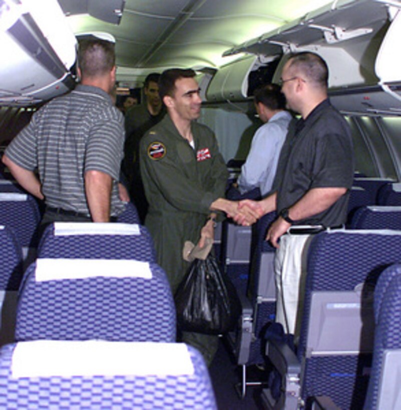 Navy Ens. Richard Bensing (center) shakes hands with a member of the repatriation crew after boarding a chartered aircraft which will fly him from Haikou, China, to Guam, on April 12, 2001, during Operation Valiant Return. Bensing is one of 24 crew members detained for 11 days after their EP-3 Aries II reconnaissance aircraft made forced landing on Hainan Island as a result of a collision with a Chinese F-8 fighter aircraft. The crew will stop briefly in Guam to change planes and will then continue on to Hawaii for military debriefings before a final reunion with families and friends on the mainland. Bensing is from Brandon, Fla. 