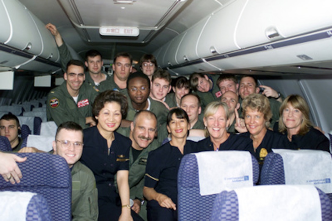 Crew members of the EP-3 pose for a photo with flight attendants of the chartered Continental Airlines aircraft which will fly them from Haikou, China, to Guam, on April 12, 2001, during Operation Valiant Return. The crew will stop briefly in Guam to change planes and will then continue on to Hawaii for military debriefings before a final reunion with families and friends on the mainland. The crew was detained for 11 days after their EP-3 Aries II reconnaissance aircraft made forced landing on Hainan Island as a result of a collision with a Chinese F-8 fighter aircraft. 