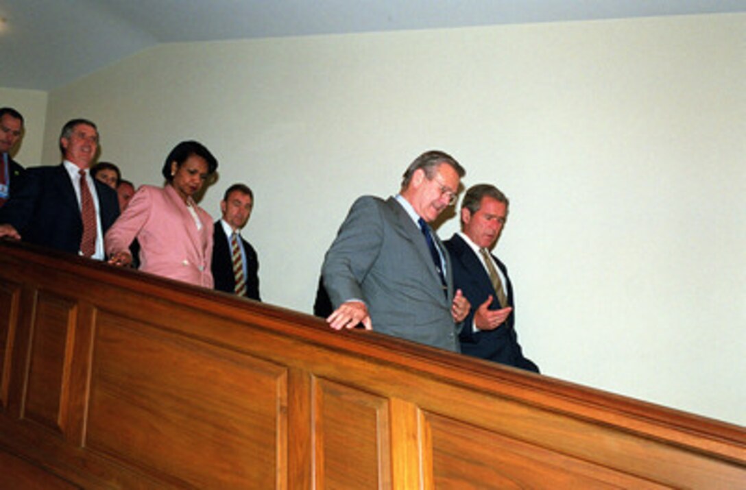 President George W. Bush (right) talks with Secretary of Defense Donald H. Rumsfeld (left) as they exit the Pentagon following briefings on the strategic review and force structuring issues on Aug. 1, 2001. National Security Advisor Condolezza Rice (second from left) and Chief of Staff to the President Andrew H. Card Jr. (left) accompanied the president to the briefing. 