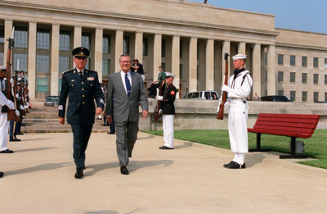 Secretary of Defense Donald H. Rumsfeld (right) escorts Secretary of National Defense of Mexico Gen. Gerardo Clemente Ricardo Vega Garcia (left) to the parade field for a ceremony welcoming him to the Pentagon on Aug. 6, 2001. Rumsfeld and Vega will later meet to discuss regional and international defense issues. 