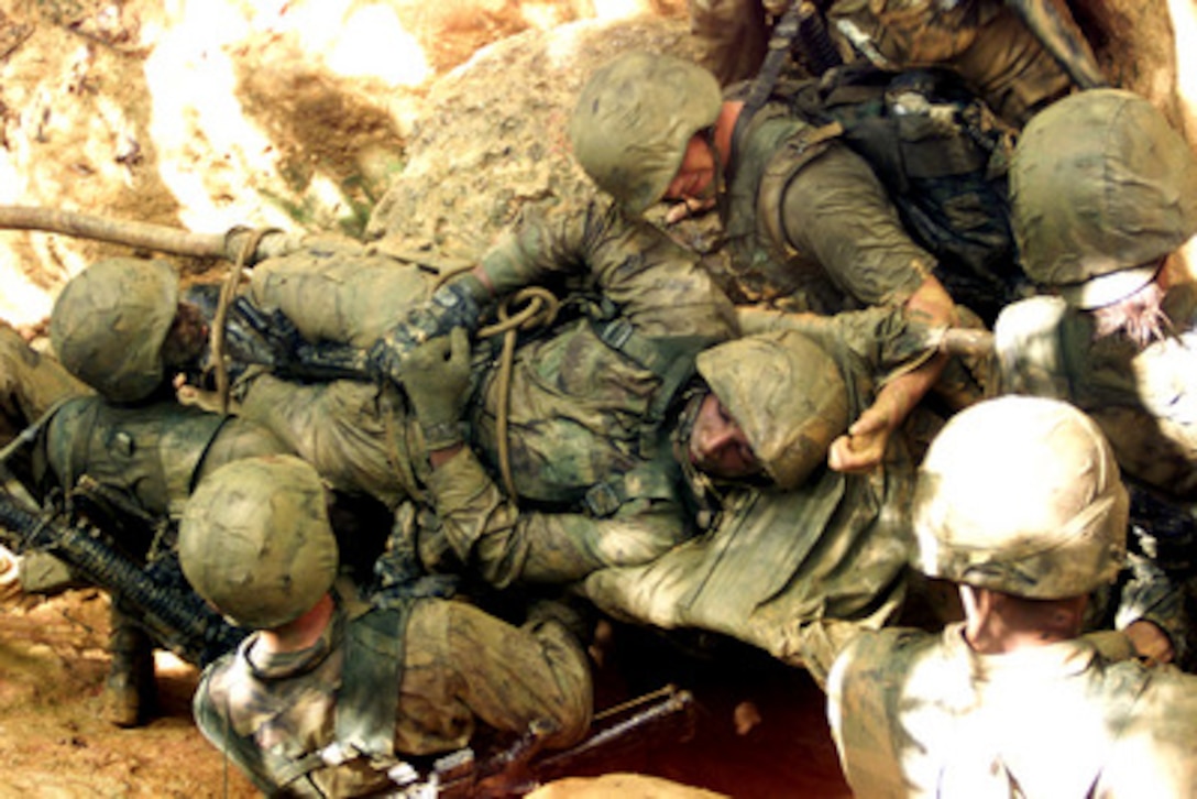 Marines from Marine Expeditionary Unit Service Support Group-31 team up to move a simulated casualty through treacherous terrain at the Jungle Warfare Training Center at Okinawa, Japan, on Aug. 3, 2001. The week long training is capped by an endurance course designed to test the Marines' endurance and leadership skills. 