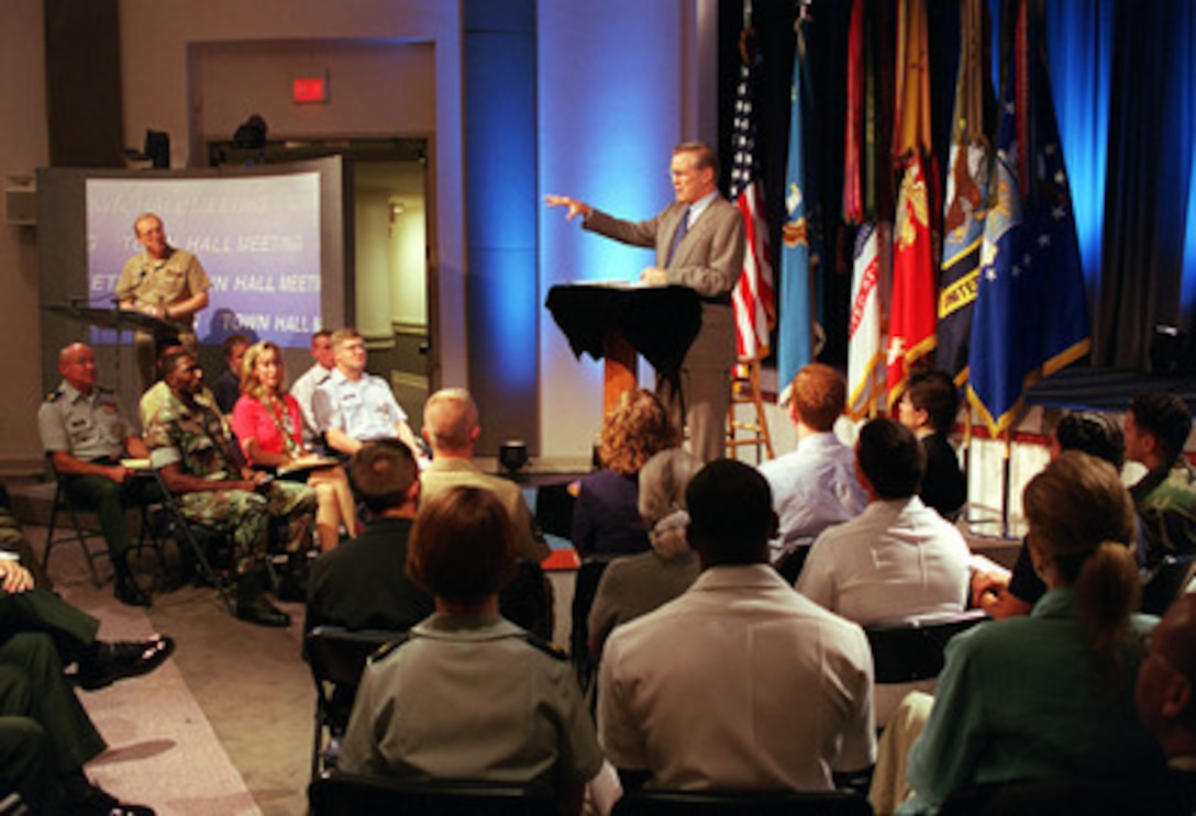 Secretary of Defense Donald H. Rumsfeld answers a question during a town hall meeting in the Pentagon on Aug. 9, 2001. In addition to taking questions from the audience in the auditorium, military or civilian DoD personnel world-wide could fax or e-mail questions to Rumsfeld from their duty stations. The event was carried live by the American Forces Radio and Television Service and streaming audio was provided on the Defense Department's web site called DefenseLINK. DoD spokesman Rear Adm. Craig Quigley (left) acted as the moderator of the program. 