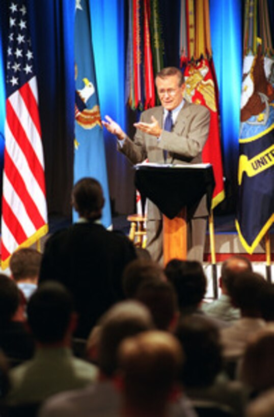 Army Staff Sgt. Marcia Triggs (standing) listens as Secretary of Defense Donald H. Rumsfeld answers her question during a town hall meeting at the Pentagon on Aug. 9, 2001. In addition to taking questions from the audience in the auditorium, military or civilian DoD personnel world-wide could fax or e-mail questions to Rumsfeld from their duty stations. The event was carried live by the American Forces Radio and Television Service and streaming audio was provided on the Defense Department's web site called DefenseLINK. Triggs, a reporter with the Army News Service, wanted to know if Rumsfeld really was considering cutting Army strength by two divisions when the Army's leadership has been requesting more personnel. Rumsfeld prefaced his reply with a broad smile and the comment, "You don't believe everything you read in the press, do you?" 