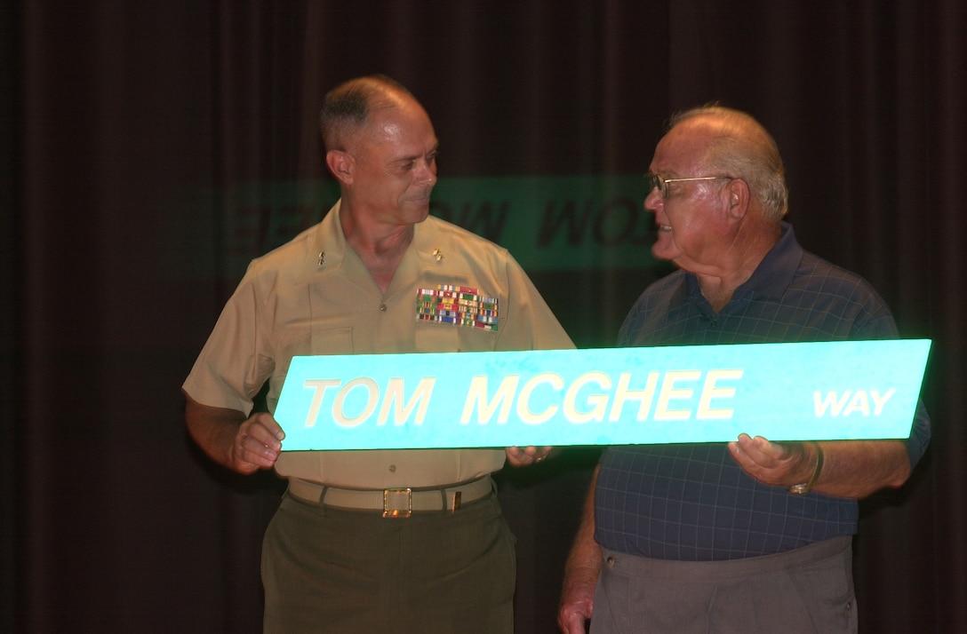 MARINE CORPS BASE CAMP LEJEUNE, N.C. - Maj. Gen. Robert C. Dickerson, the commanding general of Marine Corps Base Camp Lejeune, presents Tom McGee with a road sign June 2, which will replace the sign at the entrance to Lejeune High School here. McGee was awarded the order of the Long Leaf Pine Award along with several other awards for his lasting contributions to the community in North Carolina. (Official U.S. Marine Corps photo by Lance Cpl. Brandon R. Holgersen)