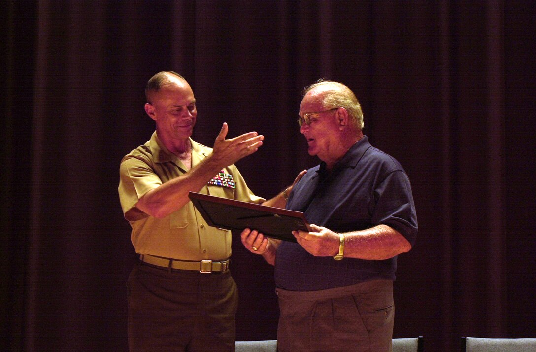 MARINE CORPS BASE CAMP LEJEUNE, N.C. - Maj. Gen. Robert C. Dickerson, the commanding general of Marine Corps Base Camp Lejeune, presents Tom McGee with the Order of the Long Leaf Pine Award here June 2. McGee was awarded the order of the Long Leaf Pine Award along with several other awards for his lasting contributions to the community in North Carolina. (Official U.S. Marine Corps photo by Lance Cpl. Brandon R. Holgersen)