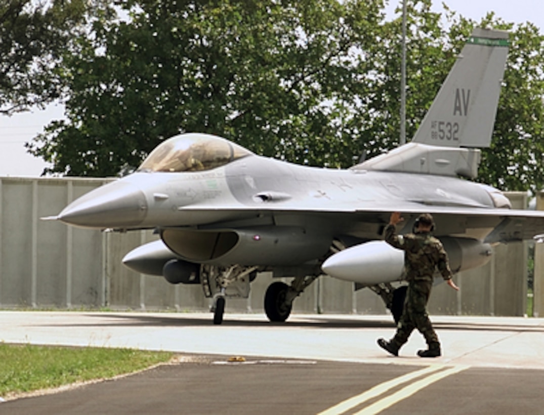 Airman 1st Class Dearl Stevens directs an F-16 Fighting Falcon after the aircraft landed at Aviano Air Base, Italy, on Aug. 10, 2001. Stevens, and the Fighting Falcon from the 555th Fighter Squadron, are participating in local exercises designed to prepare them for a NATO Tactical Evaluation. 
