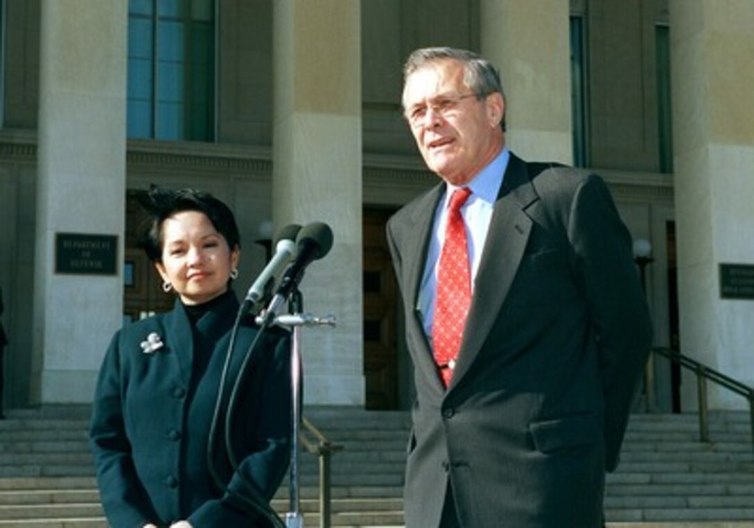 Philippines President Gloria Macapagal-Arroyo listens while Secretary of Defense Donald H. Rumsfeld responds to a reporter's question during their joint press availability at the Pentagon on Nov. 20, 2001. 