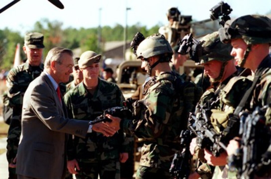 Secretary of Defense Donald H. Rumsfeld shakes hands with a Ranger squad member during his tour at Fort Bragg, N.C., on Nov. 21, 2001. Rumsfeld is visiting Fort Bragg and Pope Air Force Base to receive briefings and demonstrations on the capabilities of U.S. Special Forces made up of Army Rangers and Special Forces, Navy SEAL teams and Air Force Combat Control Teams. 