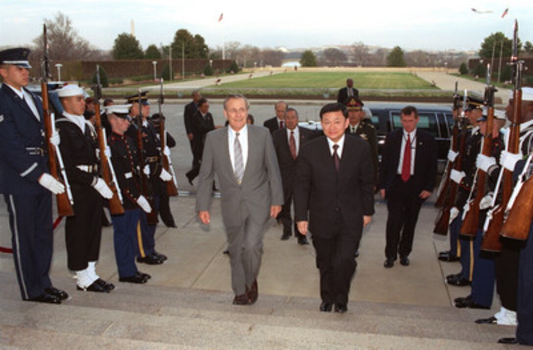 Secretary of Defense Donald H. Rumsfeld escorts visiting Prime Minister Thaksin Shinawatra, of Thailand, into the Pentagon on December 13, 2001. Shinawatra met with several top Department of Defense officials to discuss regional security issues. 