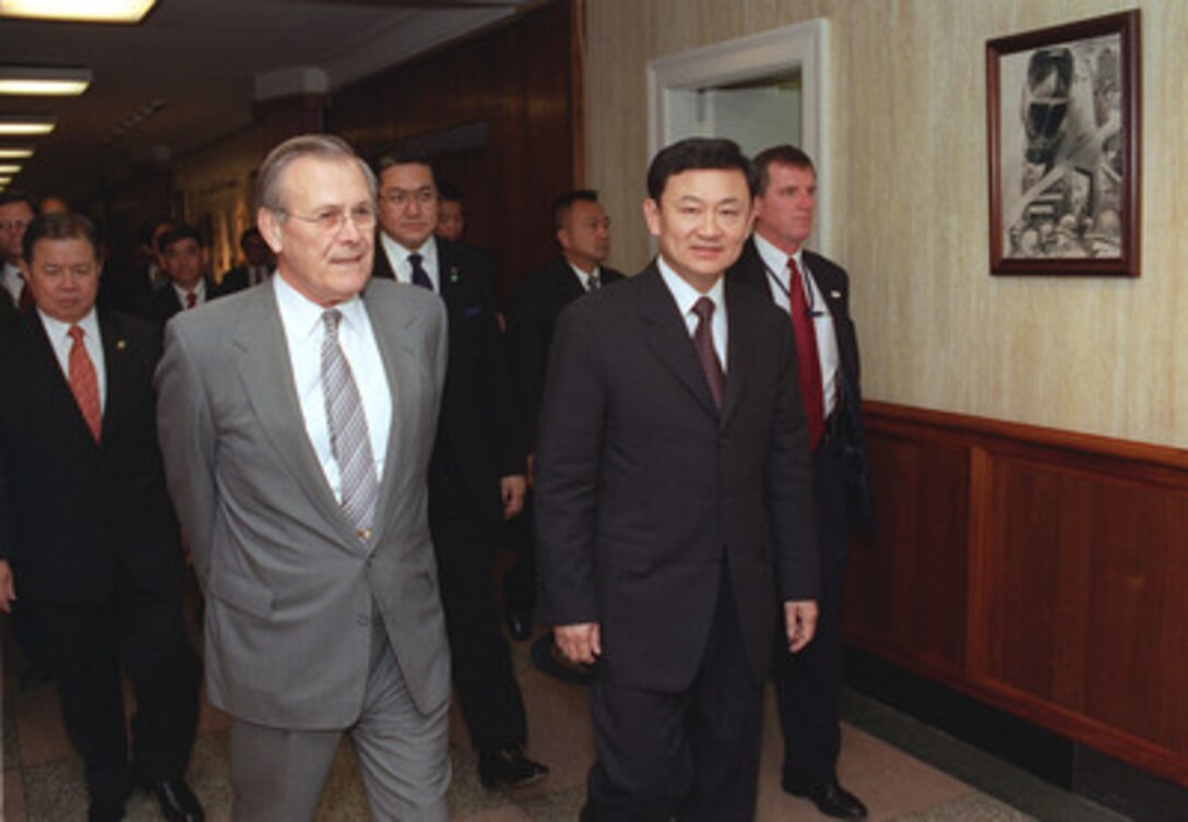 Thailand's Prime Minister Thaksin Shinawatra (right) walks to a Pentagon meeting, Dec. 13, 2001, with Secretary of Defense Donald H. Rumsfeld (left). Shinawatra met with several top Department of Defense officials, in addition to Rumsfeld, to discuss regional security issues. 