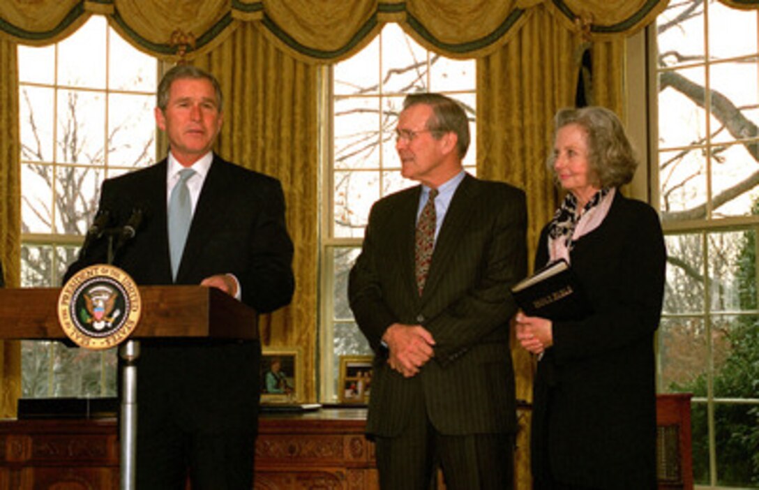 Secretary of Defense Donald H. Rumsfeld and his wife Joyce listen as President George W. Bush comments on Rumsfeld's qualifications for the job after he was sworn in as the 21st secretary of Defense in a ceremony at the White House Oval Office on Jan. 26, 2001. 