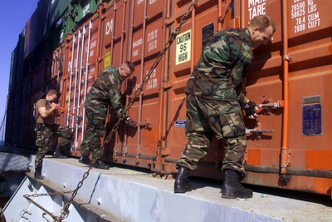 U.S. Navy Petty Officers Jerrod Denman, Nathan Wix and David Roth open cargo containers for inspection on board the container ship IBN Al Haithan in the Persian Gulf on Jan. 31, 2001. Denman, Wix and Roth are attached to the USS Higgins (DDG 76) which is conducting maritime interdiction operations in the Gulf. The Arliegh Burke class destroyer is deployed to the Gulf from its homeport of San Diego, Calif. 