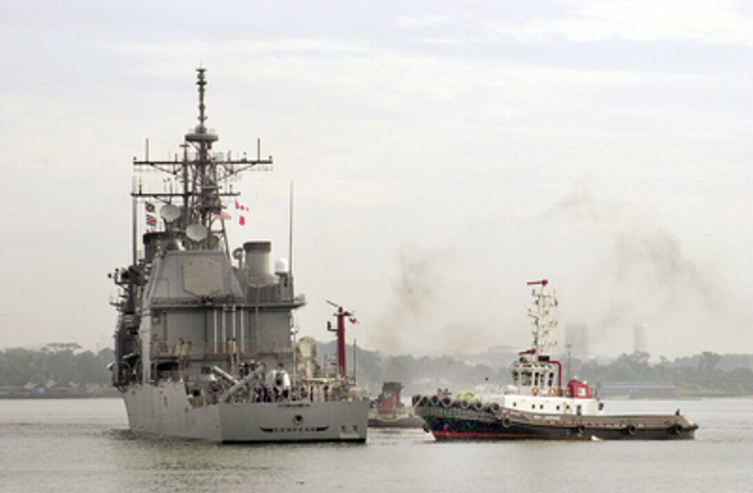 The USS Cowpens (CG 63) is assisted by tugboats as it arrives in Singapore on Feb. 2, 2001, to load humanitarian relief supplies for India's earthquake victims. The guided missile cruiser will transport the supplies to India to aid victims of the January 26th earthquake. 