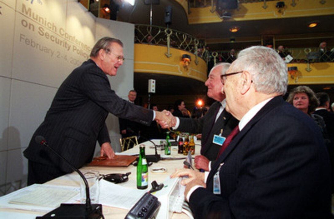 Secretary of Defense Donald H. Rumsfeld (left) is greeted by Baron Ewald-Heinrich von Kleist at the 37th Munich Conference on Security Policy Feb. 3, 2001. Rumsfeld and former Secretary of State Henry Kissinger (foreground), are this year's key speakers. Von Kleist is the originator of the conference. 
