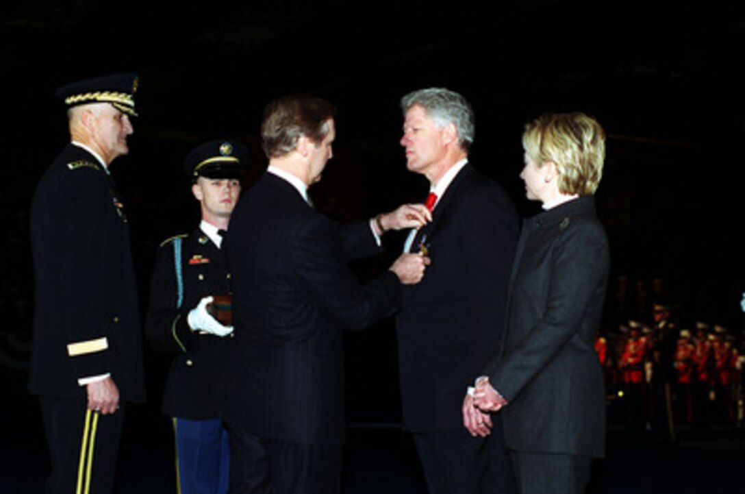 Secretary of Defense William S. Cohen presents the Department of Defense Medal for Distinguished Public Service to President Bill Clinton in a ceremonial farewell at Fort Myer, Va., on Jan. 5, 2001. Cohen and Chairman of the Joint Chiefs of Staff Gen. Henry H. Shelton (left), U.S. Army, are hosting the Armed Forces Review and Awards Ceremony in honor of the president and First Lady Hillary Rodham Clinton. 