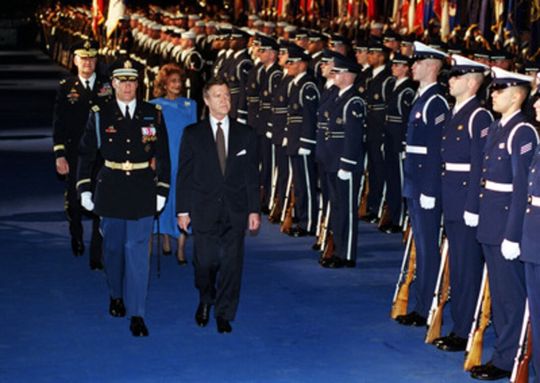 Secretary of Defense William S. Cohen (front right) reviews a joint services honor guard during a farewell ceremony in his honor at Conmy Hall, Fort Myer, Va., on Jan. 17, 2001. Chairman of the Joint Chiefs of Staff Gen. Henry H. Shelton (left rear) and Janet Langhart Cohen accompanied Cohen as he inspected the troops. Cohen is being escorted by Col. Thomas Jordan (front left), U.S. Army, the commander of troops for the ceremony. 