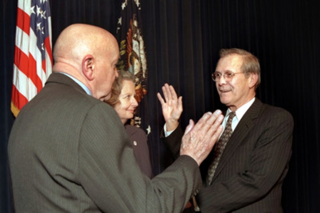 Donald H. Rumsfeld (right) is administered the oath of office as the 21st Secretary of Defense by David O. Cooke (left), as Joyce Rumsfeld holds the Bible in a ceremony at the Eisenhower Executive Office Building on Jan. 20, 2001. Rumsfeld was previously the 13th Secretary of Defense from 1975 to 1977. Cooke is the director of Administration and Management at the Department of Defense. Photo by Hyungwon Kang, White House Photo. 
