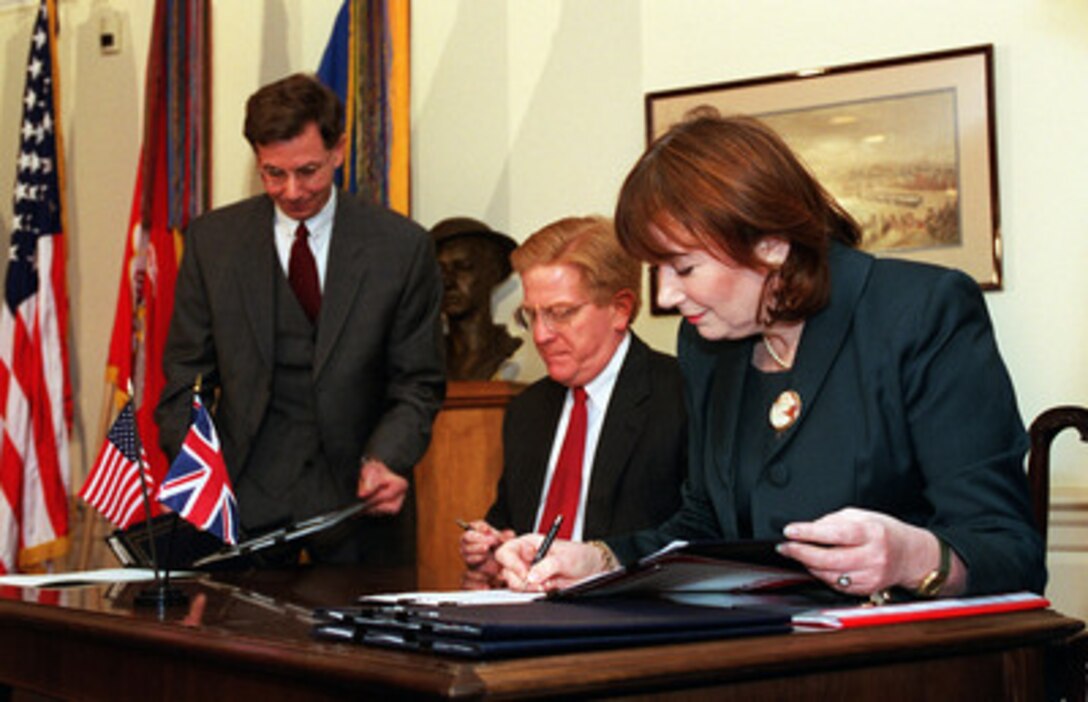 Deputy Secretary of Defense Rudy de Leon (seated left) and Minister of State For Defence Procurement Baroness Symons, of the United Kingdom, sign a memorandum of understanding on the next phase of the Joint Strike Fighter program in the Pentagon on Jan. 17, 2001. The Baroness committed her government to an additional $2 billion funding for the development of the multi-mission aircraft. 
