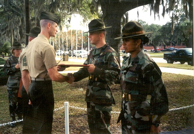 Staff Sgt. Randy Scifo shakes the hand of the Bravo co. commander during his and Rosalia's promotion  ceremony at Parris Island, Nov. 30, 2001.  The Scifos were promoted the rank of sergeant and staff sergeant on the same days.