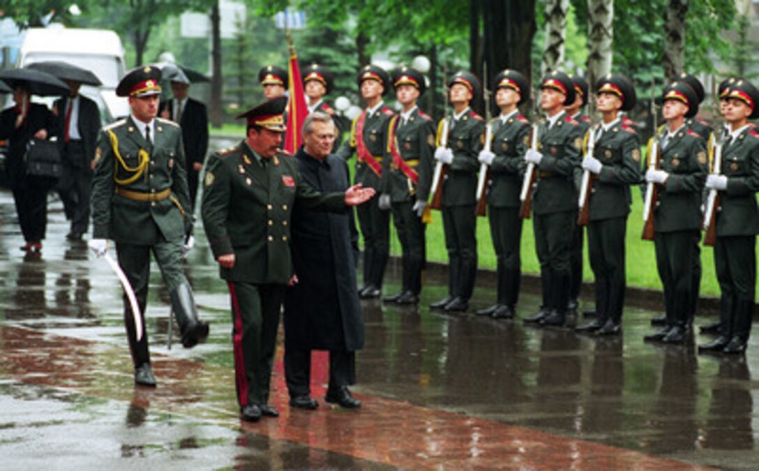 Secretary of Defense Donald H. Rumsfeld (center) is welcomed with full military honors by Ukrainian Minister of Defense Gen. Oleksander Kuzmuk (left) as he arrives at the Ministry of Defense in Kiev, Ukraine, on June 5, 2001. Following the ceremony, the two defense leaders will meet to discuss a variety of security issues of interest to both nations. Kiev is Rumsfeld's second stop on a seven-day, seven-nation, European tour. 
