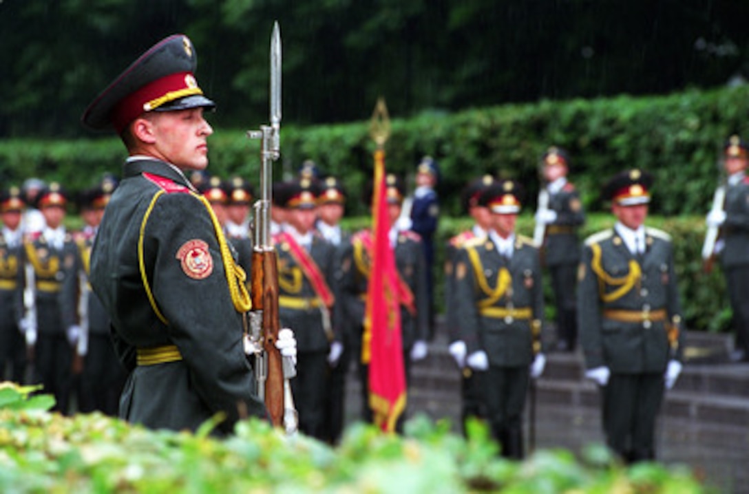A Ukrainian Army honor guard stands in the rain as Secretary of Defense Donald H. Rumsfeld places a wreath at the War Memorial in Kiev, Ukraine, on June 5, 2001. Rumsfeld is visiting Kiev to meet with his counterpart Ukrainian Minister of Defense Gen. Oleksander Kuzmuk (center) during the second stop of a seven-day, seven-nation, European tour. 