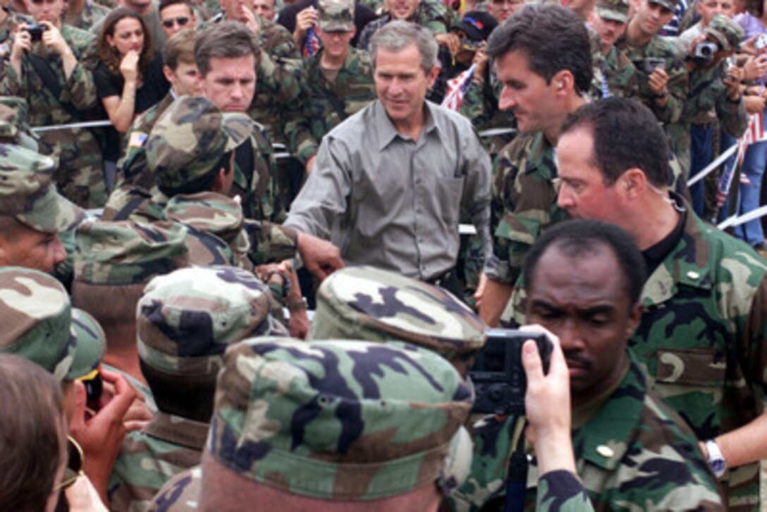 President George W. Bush shakes hands with American soldiers during his visit to Camp Bondsteel in Kosovo on July 24, 2001. Bush is visiting the Task Force Falcon soldiers to show support for the troops in Kosovo. The president signed the fiscal year 2001 Emergency Supplemental Appropriations legislation which contains $1.9 billion for military pay, benefits and health care among other categories during his visit. 