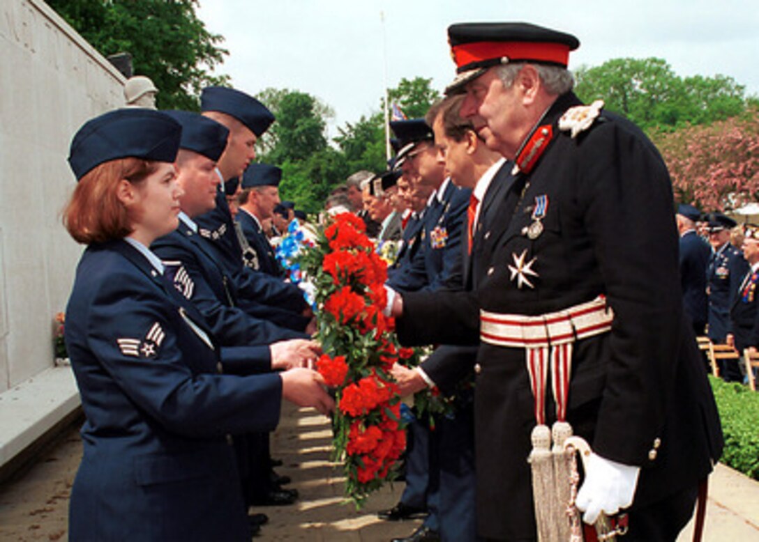 Senior Airman Rebecca A. Baucum (left) passes a wreath to Her Majesty's Lord Lieutenant of Cambridgeshire James Crowden during the Madingley Memorial Day Commemorative Service on May 28, 2001, at the Cambridge American Military Cemetery, Coton, Cambridge, England. This year marks the 57th annual memorial service honoring the American servicemen and women who are buried here and those listed on the Wall of the Missing. The cemetery was dedicated on July 16, 1956, as the only permanent American World War II cemetery in the British Isles. Baucum is attached to the 48th Communication Squadron, 48th Fighter Wing, RAF Lakenheath. 