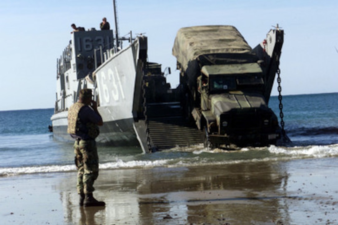 Petty Officer 3rd Class Victor Guerrero watches as a 5 ton truck is backed onto a Landing Craft Utility as the 31st Marine Expeditionary Unit back-loads during Exercise Tandem Thrust 2001 May 25, 2001, at Shoalwater Bay Training Area, Queensland, Australia. Guerrero is deployed as part of Beachmaster Unit 1, Detachment WESTPAC, to participate in the combined military training exercise involving more than 18,000 U.S., Australian, and Canadian personnel who are training in crisis action planning and execution of contingency response operations. 