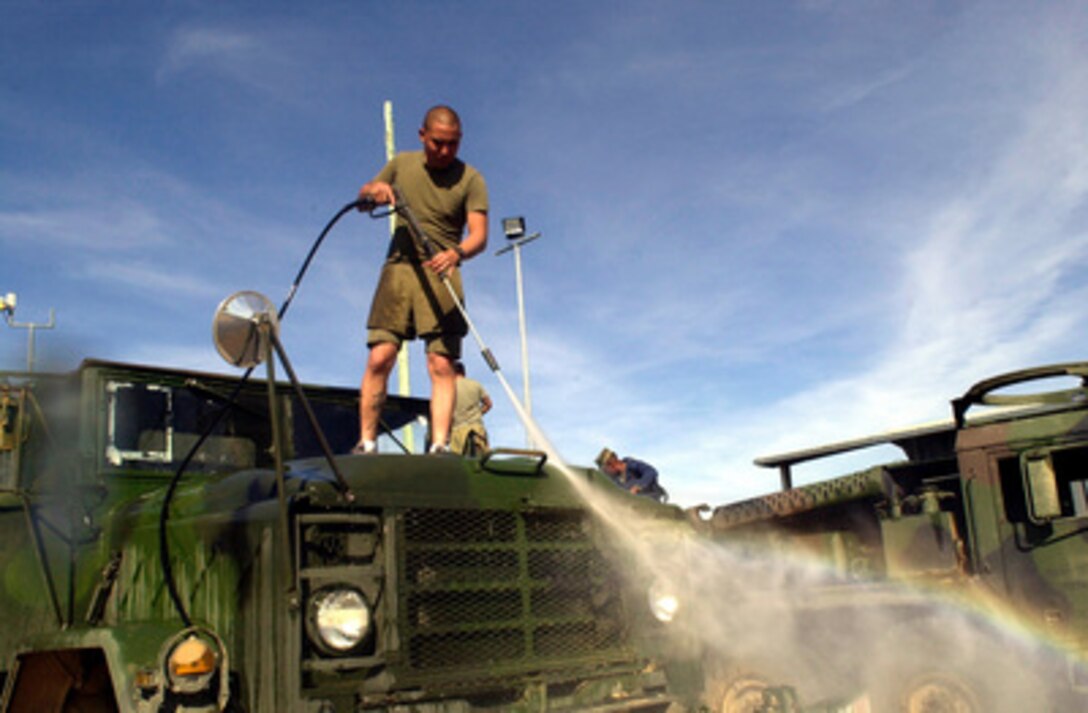 Sgt. Cheston Souza washes the windows of a 5 ton military truck before reloading it aboard a ship during Exercise Tandem Thrust 2001 in Rockhampton, Australia on May 26, 2001. Souza is participating in a combined military training exercise involving more than 18,000 U.S., Australian, and Canadian personnel who are training in crisis action planning and execution of contingency response operations. The vehicles are washed before coming into Australia and just prior to leaving to eliminate the spread of agricultural pests. Souza is from the Marine Wing Support Squadron, Marine Corps Air Station, Yuma, Arizona. 