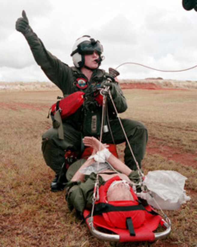 Petty Officer 3rd Class Raymond Munn gives a thumbs up to signal he is ready to be hoisted by helicopter during a Search And Rescue training exercise at Talofofo, Guam, on May 31, 2001. Munn, from Cheyenne, Wyo., is a Navy hospital corpsman deployed with Helicopter Combat Support Squadron 5. 