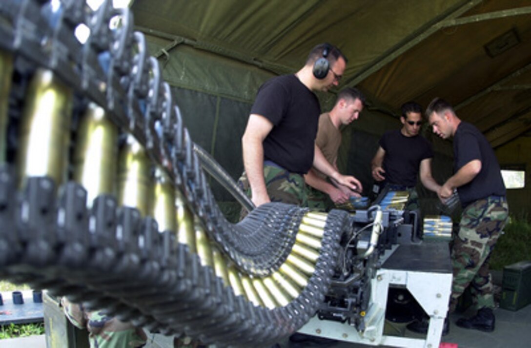 Staff Sgts. Scott Straley (left), John Hurley Jr. (2nd from left), Mike Schoenly (center) and Senior Airman Brian Tremblay (right) use a Universal Ammunition Loader to upload 20 mm ammunition into an F-16 Fighting Falcon at Malacky Air Base, Republic of Slovakia, on June 7, 2001. Straley, Hurley and Tremblay are attached to the 31st Maintenance Squadron. Schoenly is attached to the 31st Transportation Squadron. 