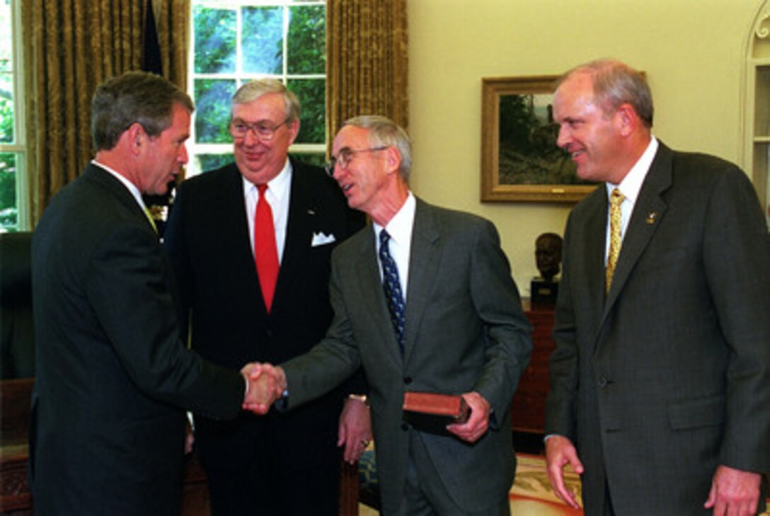 President George W. Bush (left) congratulates Secretary of the Navy Gordon England (center), Secretary of the Air Force James Roche (2nd from left) and Secretary of the Army Thomas White (right) following their swearing in ceremony in the White House Oval Office on June 18, 2001. 