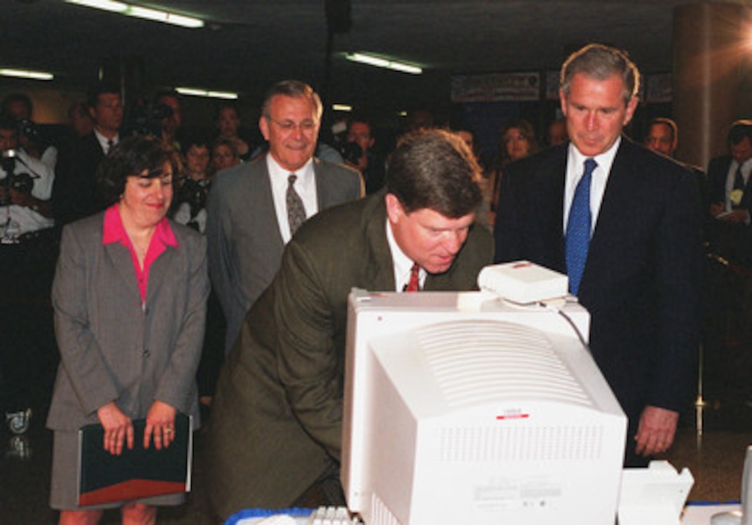 Paul Singleton (center) demonstrates computer technology for deaf and hard of hearing users to President George W. Bush (right), Dinah Cohen (left) and Secretary of Defense Donald H. Rumsfeld (2nd from left) in the Pentagon on June 19, 2001. Bush is in the Pentagon to visit the Computer/Electronic Accommodations Program Technology Evaluation Center (CAPTEC), and will address Department of Defense personnel. CAPTEC provides assistive technology, such as adaptive computers, electronic equipment and devices specially designed to meet the needs of employees with disabilities. Singleton is a program analyst with CAPTEC. Cohen is Director of CAPTEC. 