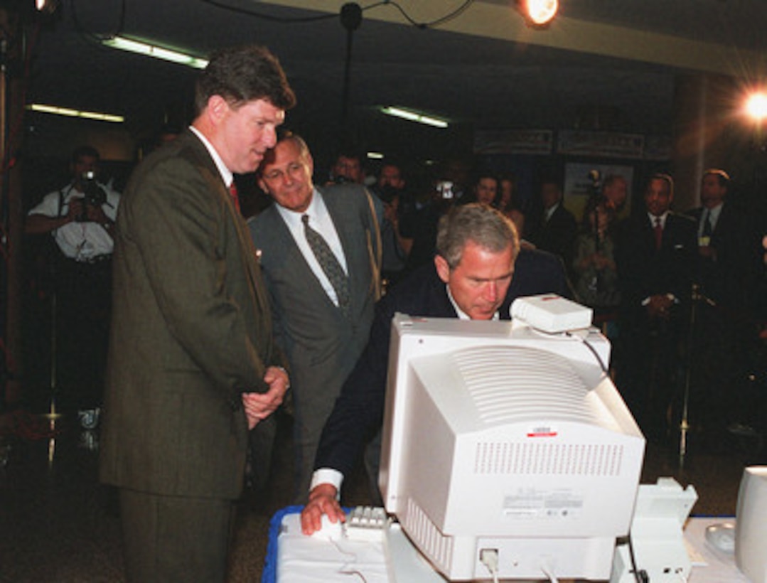 President George W. Bush uses computer technology to send a message for the deaf and hard of hearing at the Computer/Electronic Accommodations Program Technology Evaluation Center (CAPTEC), as Paul Singleton (left) program analyst with CAPTEC, and Secretary of Defense Donald H. Rumsfeld (center) look on in the Pentagon on June 19, 2001. Bush is in the Pentagon to visit the (CAPTEC), and will address Department of Defense personnel. CAPTEC provides assistive technology, such as adaptive computers, electronic equipment and devices specially designed to meet the needs of employees with disabilities. 