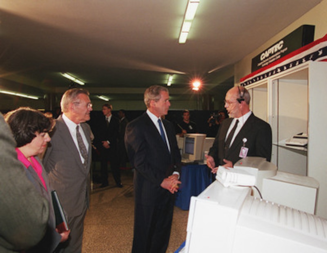 Mike Young (right) explains assistive technology for the needs of persons with dexterity disabilities to President George W. Bush (second from right), Secretary of Defense Donald H. Rumsfeld (second from left) and Dinah Cohen (left) in the Pentagon on June 19, 2001. Bush is in the Pentagon to visit the Computer/Electronic Accommodations Program Technology Evaluation Center (CAPTEC), and will address Department of Defense personnel. CAPTEC provides assistive technology, such as adaptive computers, electronic equipment and devices specially designed to meet the needs of employees with disabilities. Young is a support analyst with CAPTEC. Cohen is Director of CAPTEC. 