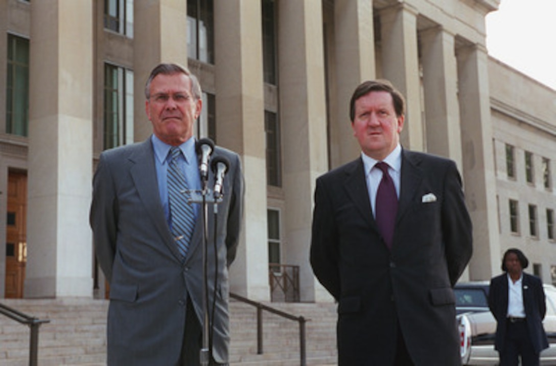 Secretary of Defense Donald H. Rumsfeld (left) and NATO Secretary General Lord George Robertson (right) listen to a reporter's question during a joint media availability following their Pentagon meeting on June 20, 2001. 