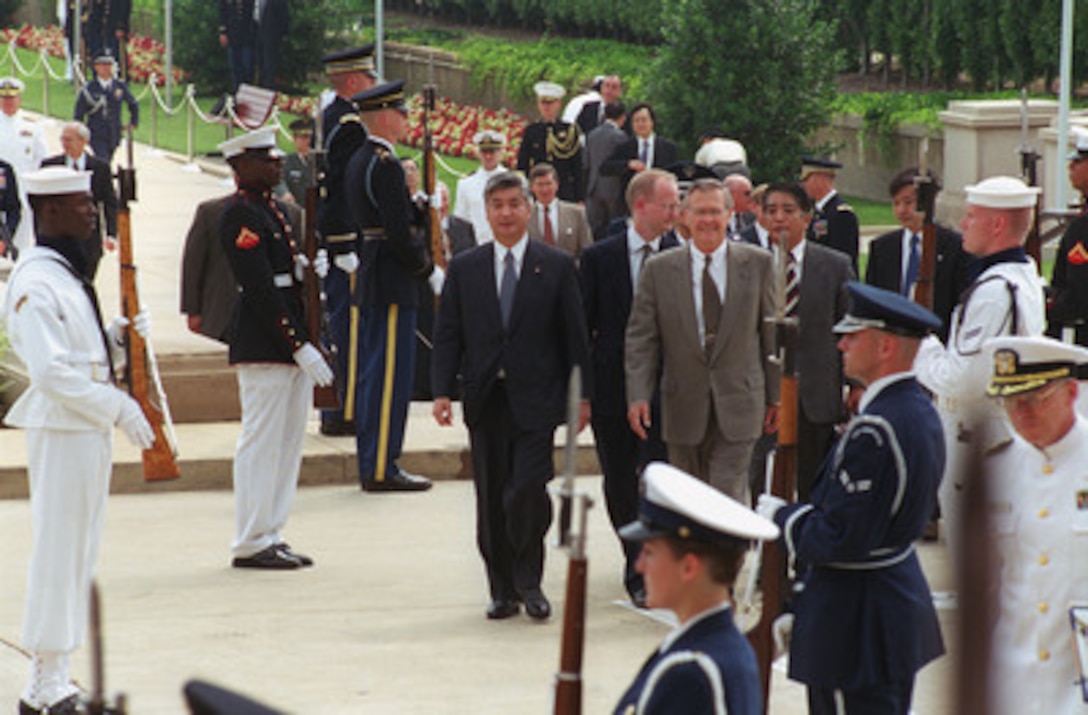 Secretary of Defense Donald H. Rumsfeld (right) escorts his guest, Gen Nakatani, director general of the Japan Defense Agency, back to the Pentagon following a military welcoming ceremony held in his honor, June 22, 2001, on the adjacent parade field. The two defense leaders will meet to discuss a variety of regional and global defense issues of interest to both nations. 