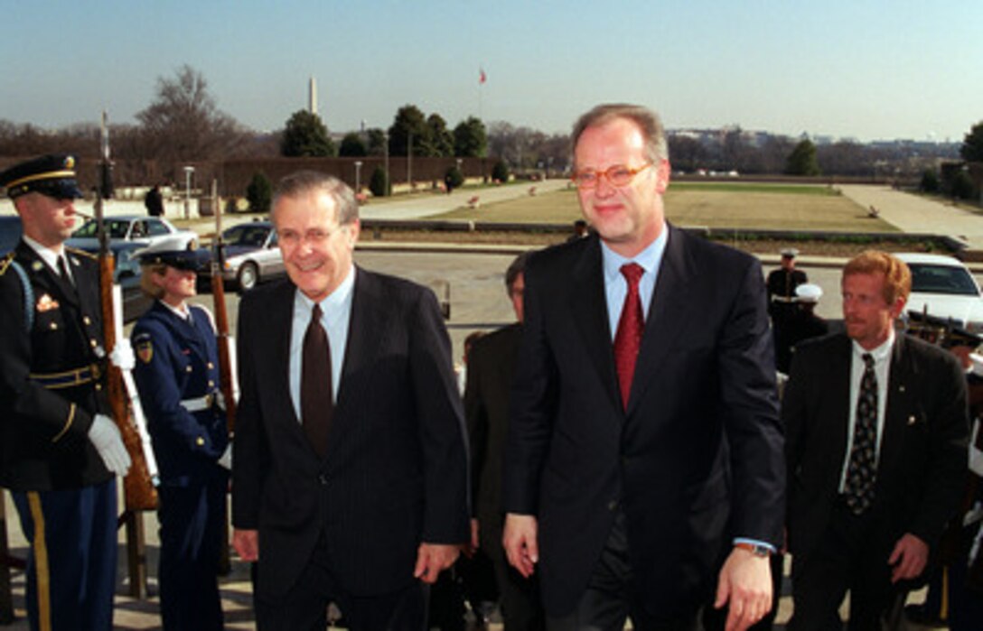 Secretary of Defense Donald Rumsfeld (left) escorts Minister of Defense Rudolf Scharping, of Germany, through an honor cordon and into the Pentagon on March 8, 2001. The two men will meet to discuss a range of security issues of interest to both nations. 