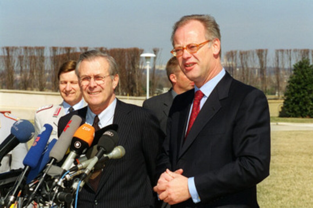 Secretary of Defense Donald Rumsfeld (left) and German Defense Minister Rudolf Scharping meet with international reporters during an impromtu press conference on the Pentagon River Parade Field on March 8, 2001. Rumsfeld and Scharping spoke briefly to the reporters at the conclusion of a morning meeting during which the two men discussed a broad range of security issues of interest to both nations. 