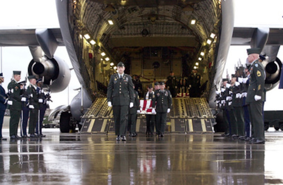 U.S. Army casket bearers carry the remains of one of six U.S. servicemen killed in a March 12 training exercise in Kuwait from a C-17 Globemaster III at Ramstein Air Base, Germany, on March 15, 2001. The remains will be transported to the Landstuhl Regional Medical center for identification. 