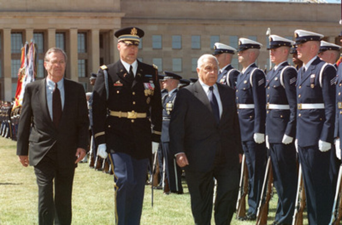 Israeli Prime Minister Ariel Sharon (right) is escorted by Col. Thomas Jordan (center), U.S. Army, and Secretary of Defense Donald H. Rumsfeld (left) as he inspects the honor guard during his arrival at the Pentagon on March 19, 2001. Sharon and Rumsfeld will later meet to discuss regional and international security issues of interest to both nations. 