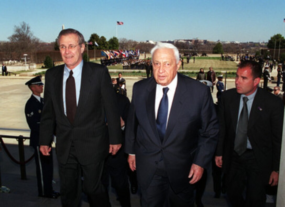 Secretary of Defense Donald H. Rumsfeld (left), escorts Israeli Prime Minister Ariel Sharon (center) into the Pentagon at the conclusion of a full honor arrival ceremony for Sharon at the Pentagon on March 19, 2001. Rumsfeld and Sharon will meet to discuss regional and international security issues of interest to both nations. 