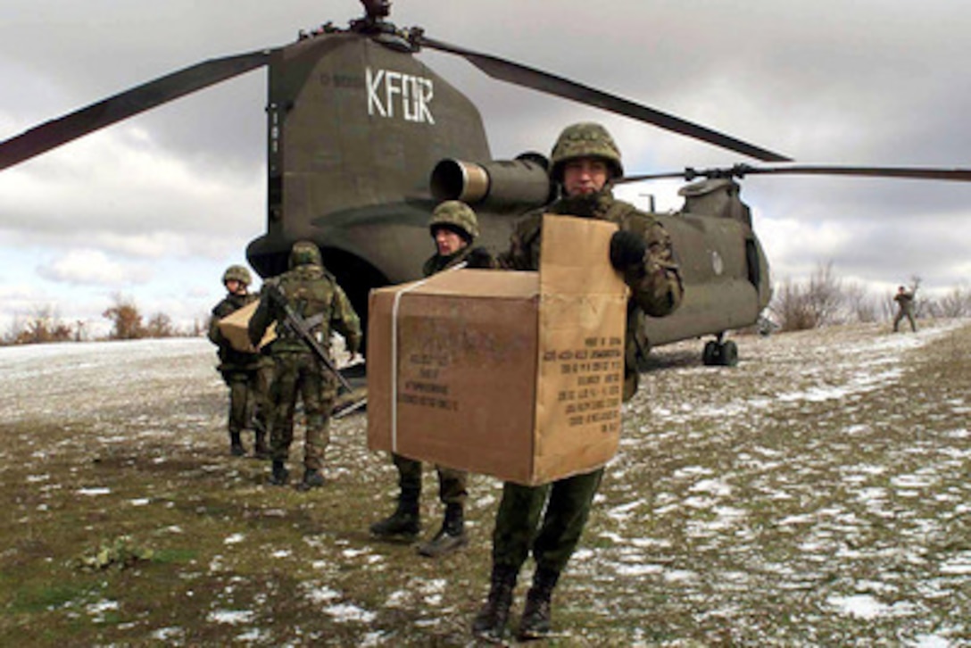 Polish, Ukrainian and American soldiers unload boxes of clothing from a U.S. Army CH-47 Chinook helicopter in a field near the village of Drenova Glava, Kosovo, on Feb. 19, 2001. The donated clothing was flown to the isolated village by Company F 159th Army Aviation because the impassable roads challenged KFOR vehicles. KFOR is the NATO-led, international military force in Kosovo on the peacekeeping mission known as Operation Joint Guardian. 
