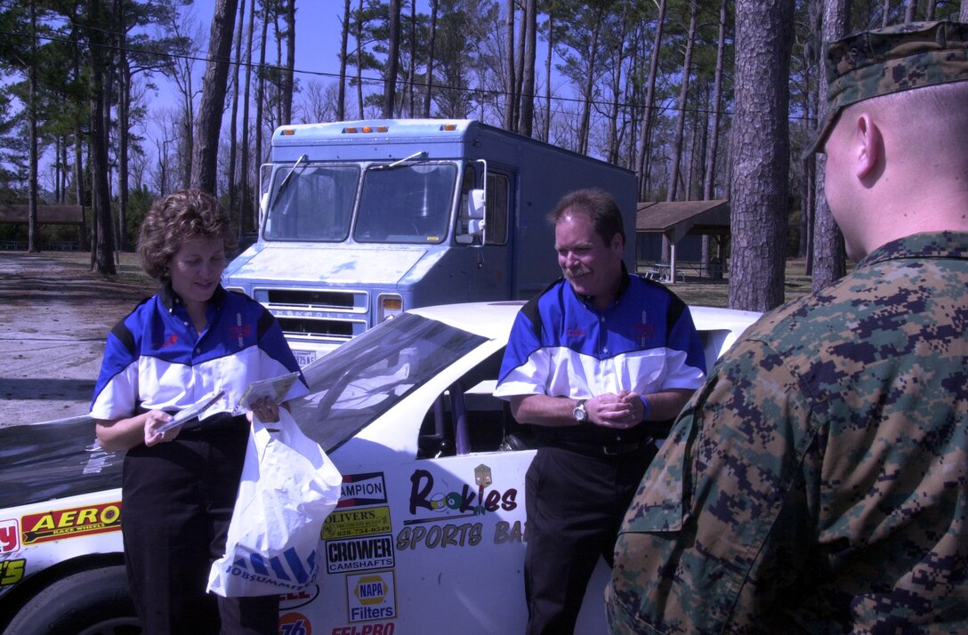 MARINE CORPS BASE CAMP LEJEUNE, N.C. - National Association of Stock Car Auto Racing driver, Sandy Rose Bauler, and one of her crewmembers, Eddie Bryans of Driven 2 Dare, Inc., hand out t-shirts after the "Need for Speed" motor vehicle safety seminar took place at Marston Pavilion March 21. The goal of the program is to reduce motor vehicle accidents and mishaps involving Marines, sailors and civilians assigned to the Marine Corps Base Camp Lejeune area by at least 50 percent, according to Col. D.J. Anderson, assistant chief of staff, installation security, safety and anti-terrorism force protection. (Official Marine Corps photo by Lance Cpl. Matthew K. Hacker)