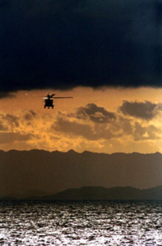 An SH-60B Seahawk helicopter flies channel guard for the aircraft carrier USS Kitty Hawk (CV 63) as it passes through the Leyte Gulf on April 15, 2001. The Seahawk is attached to Helicopter Anti-Submarine Squadron 14, Atsugi Naval Air Facility, Japan. The Kitty Hawk is deployed from Yokosuka Naval Base, Japan. 