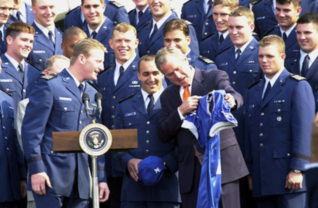 Cadet Mike Thiesen (left), quarterback for the U.S. Air Force Academy Falcon football team, presents a team jersey to President George W. Bush on the White House South Lawn on May 4, 2001. The team was in Washington, D.C., to receive the Commander in Chief's Trophy from the president. The trophy is awarded yearly to the winner of a round robin tournament between the service academies. 