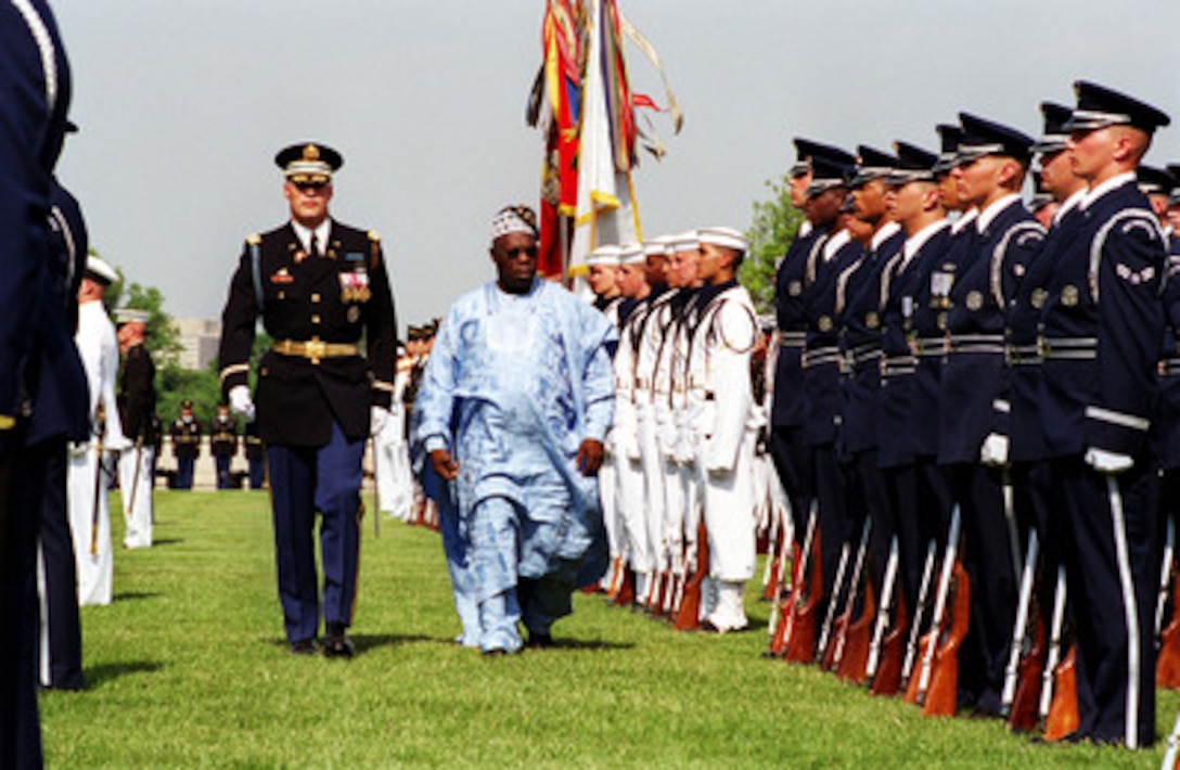 Col. Thomas M. Jordan (left), U.S. Army, commander of troops, escorts President Olusegun Obasanjo (right), of the Federal Republic of Nigeria, as he inspects the troops during his Pentagon welcoming ceremony on May 10, 2001. 